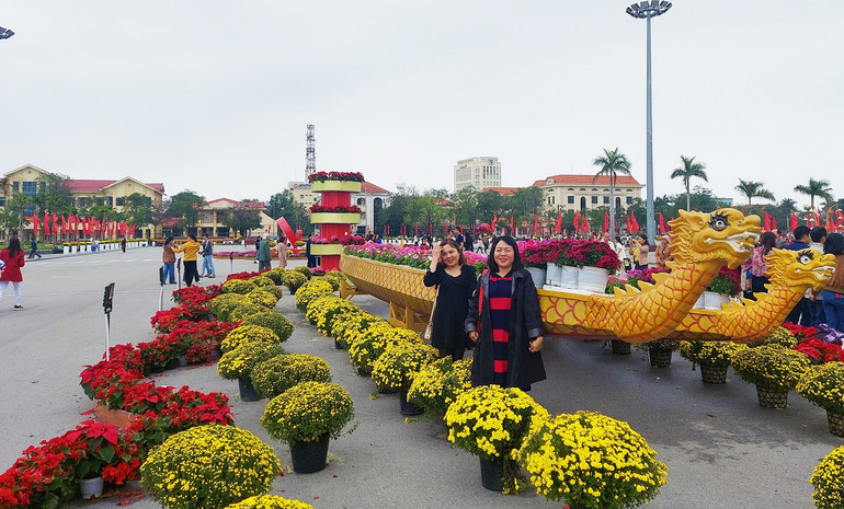 Chụp ảnh lưu niệm bên những chiếc thuyền hoa.