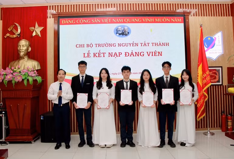 Đồng chí Phạm Sỹ Cường, Bí thư Chi bộ, Hiệu trưởng Trường THCS và THPT Nguyễn Tất Thành trao Quyết định kết nạp Đảng cho các học sinh.