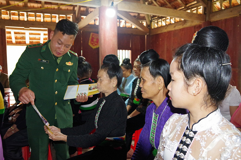 Cán bộ Đồn Biên phòng Mường Pồn phát tờ rơi tuyên truyền cho người dân trên địa bàn về phòng chống tội phạm và xuất nhập cảnh trái phép.