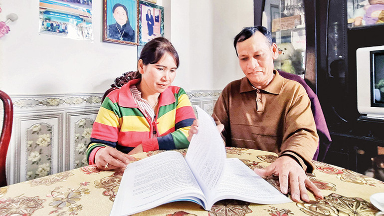 Ông Ha Tin và trưởng thôn Liêng Bông lần giở những trang tài liệu về sản xuất nông nghiệp công nghệ cao trong những lần tham dự hội thảo.