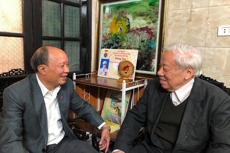 Bí thư Chi bộ 8 Nguyễn Duy Long trao đổi với ông Phan Văn Lai về công tác đảng.