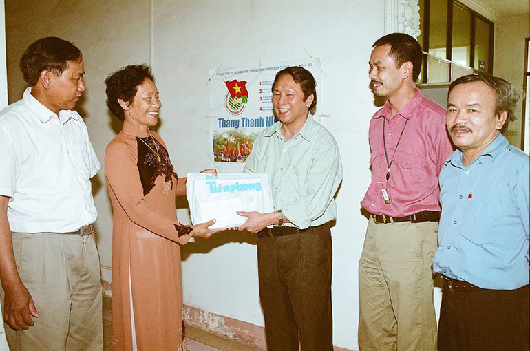 Nhà báo Dương Xuân Nam (giữa) trao quà cho nữ dân quân Ngô Thị Thương, người đã dùng súng trường K44 bắn rơi máy F105 của Mỹ tại Ngã ba Đồng Lộc.