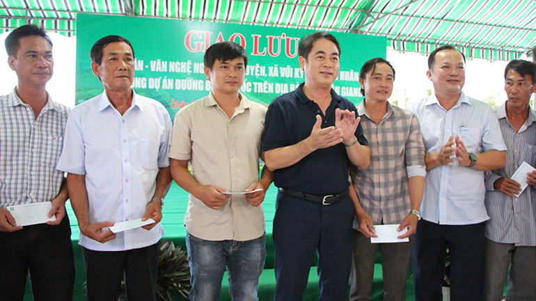 Bí thư Tỉnh ủy Hậu Giang (đứng giữa) trao quà tặng các hộ dân có cao tốc đi qua.