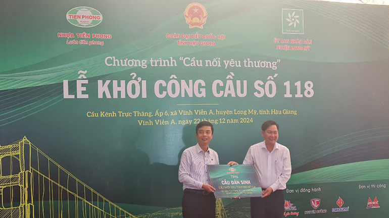 Đại diện nhà tài trợ trao bảng tượng trưng tặng cầu dân sinh cho lãnh đạo huyện Long Mỹ.