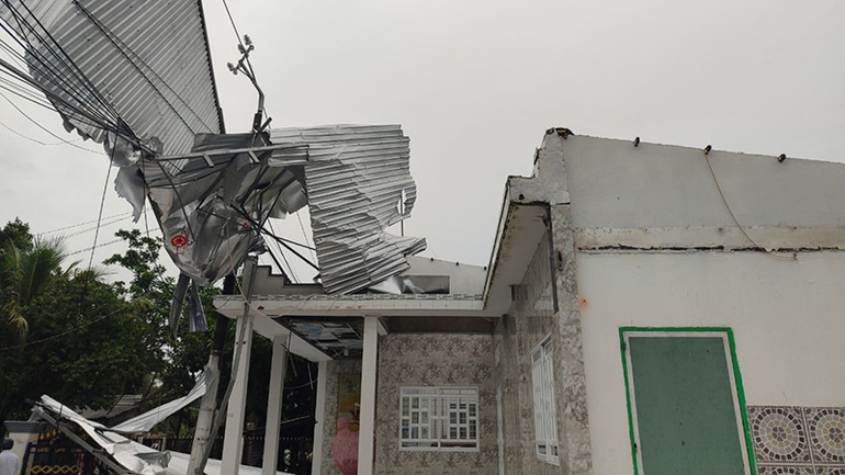 Mái nhà bị dông lốc cuốn còn vướng trên đường dây điện.