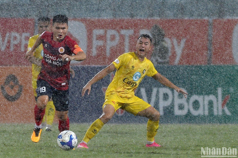 Cơn mưa lớn ảnh hưởng đến lối chơi của hai đội. (Ảnh: TRẦN HẢI)