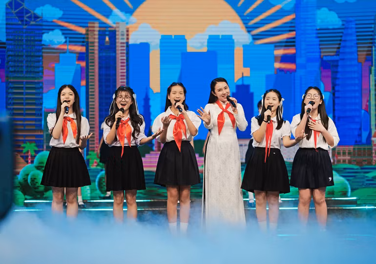 Giọng ca nữ Bảo Trâm xuất hiện trong tà áo dài trắng cùng khăn quàng đỏ.