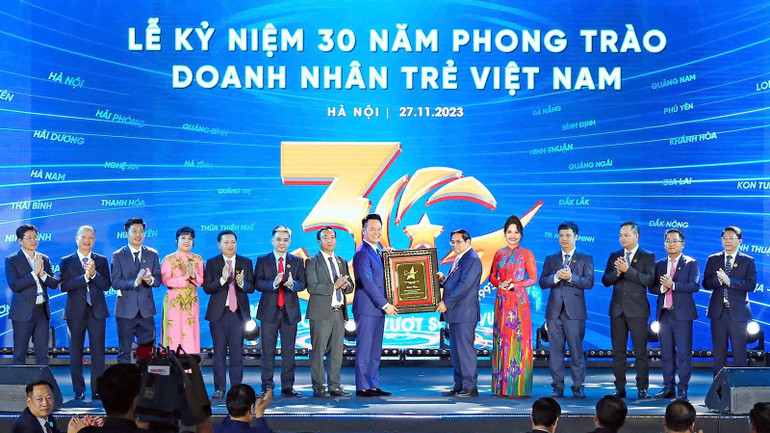 Thủ tướng Phạm Minh Chính (thứ 6 từ phải qua) cùng đại diện Hội Doanh nhân trẻ Việt Nam và các đơn vị liên quan tại Lễ kỷ niệm 30 năm phong trào Doanh nhân trẻ Việt Nam.