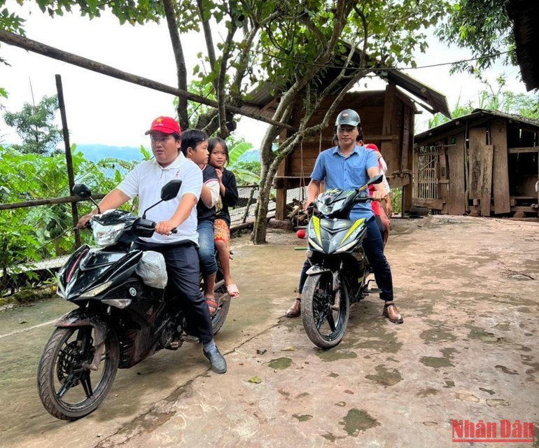 Cán bộ huyện Nậm Pồ về bản đón từng trẻ nhỏ đến điểm tiêm. (Ảnh: LÊ LAN)