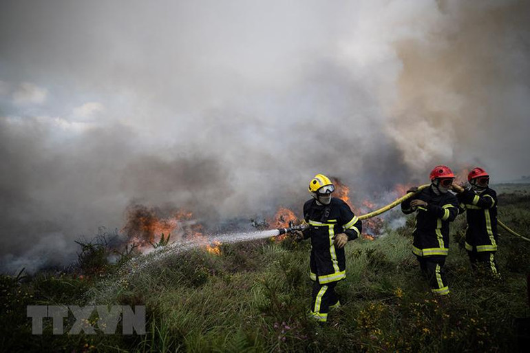 Nhân viên cứu hỏa nỗ lực khống chế các đám cháy rừng do nắng nóng tại Brasparts, Pháp, ngày 19/7. (Nguồn: AFP/TTXVN)