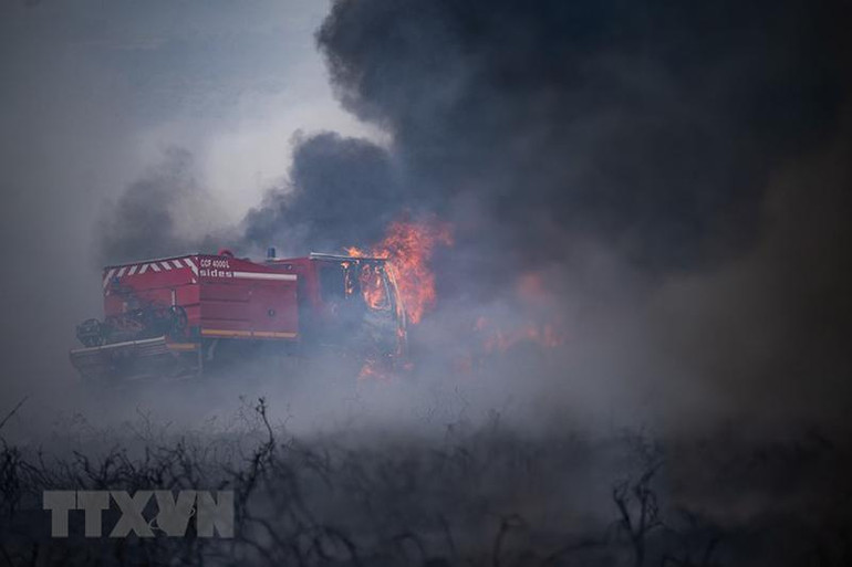 Nhân viên cứu hỏa nỗ lực khống chế các đám cháy rừng do nắng nóng tại Brasparts , Pháp, ngày 19/7. (Nguồn: AFP/TTXVN)