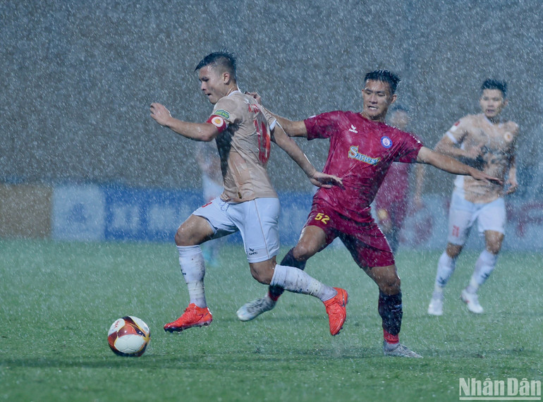 Cơn mưa nặng hạt khiến các cầu thủ thi đấu khó khăn. (Ảnh: TRẦN HẢI)