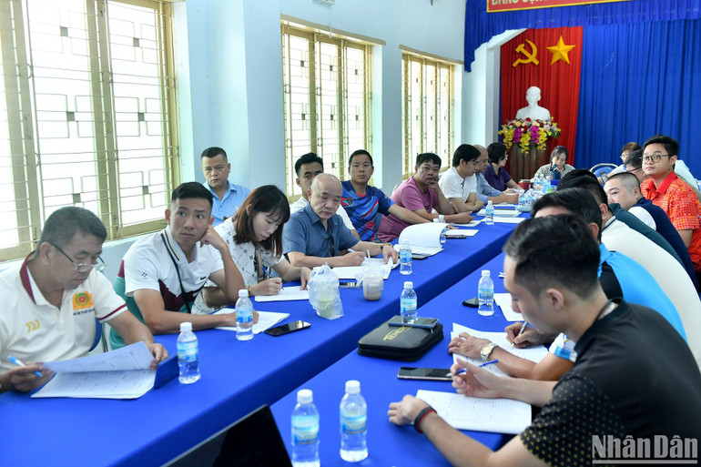 Các huấn luyện viên, trưởng đoàn theo dõi công tác bốc thăm chia bảng.