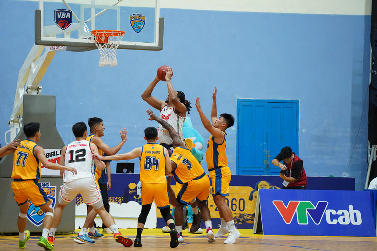 John Fields (áo trắng giữa) tấn công rổ trước 3 cầu thủ Nha Trang Dolphins.