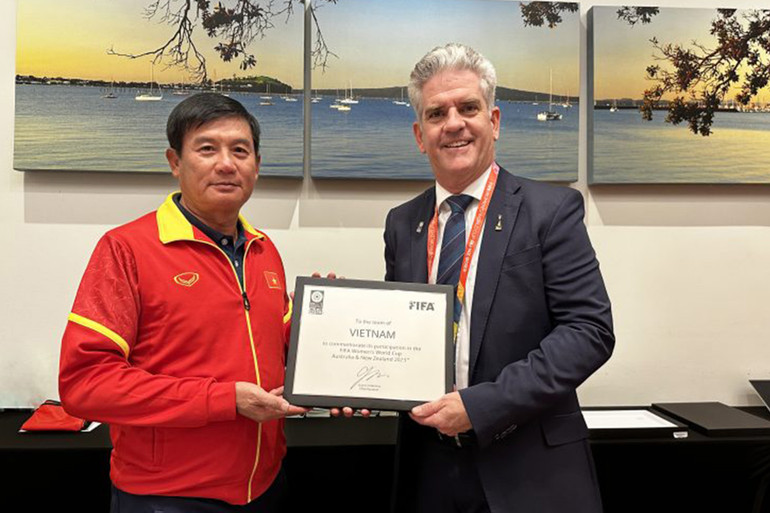 Đại diện FIFA trao bảng danh vị chứng nhận đội tuyển nữ Việt Nam tham dự World Cup nữ 2023 tại New Zealand và Australia. Trưởng đoàn Trương Hải Tùng đại diện toàn đội nhận bảng danh vị. (Ảnh: VFF)