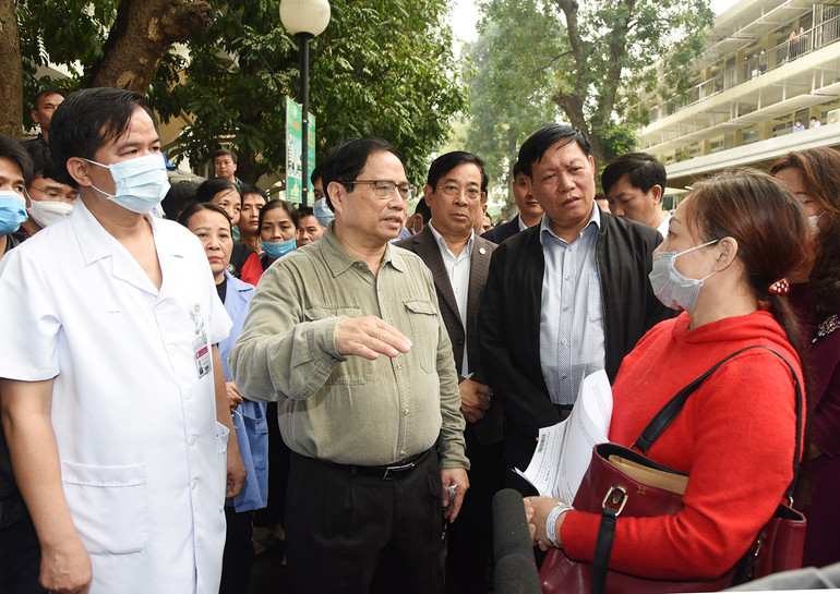 Thủ tướng trò chuyện với người nhà bệnh nhân về tình hình đáp ứng vật tư y tế và thuốc men tại Bệnh viện Bạch Mai.