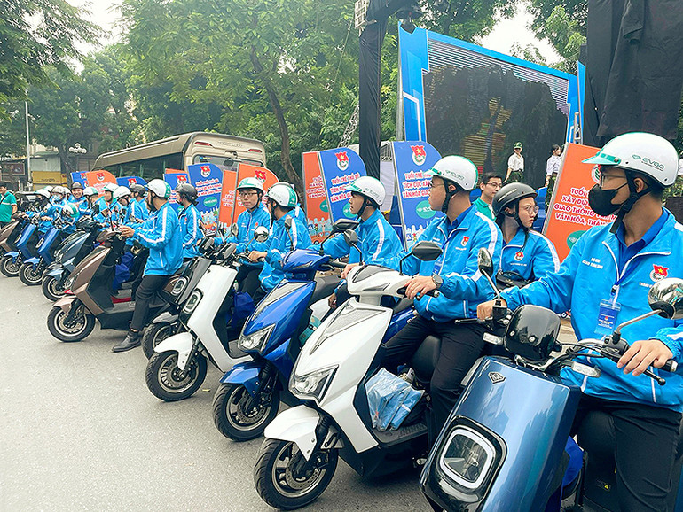 Các bạn trẻ diễu hành tuyên truyền bằng xe máy điện thân thiện với môi trường.