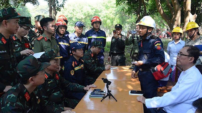 Trưởng đoàn Phạm Văn Tỵ và thành viên lực lượng cứu hộ, cứu nạn Việt Nam làm việc tại hiện trường với ông He U Kyaw Soe Win, Bộ trưởng Du lịch và Khách sạn Myanmar. (Ảnh: Báo Quân đội nhân dân từ Myanmar)