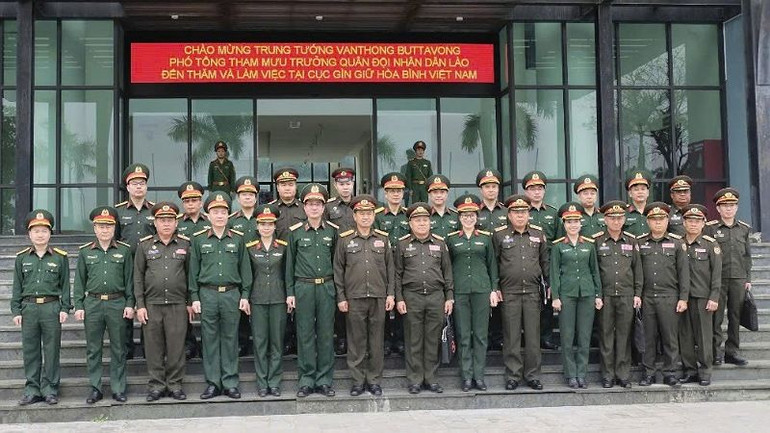 Đoàn đại biểu Bộ Quốc phòng nước Cộng hòa Dân chủ Nhân dân Lào chụp ảnh kỷ niệm với cán bộ, chiến sĩ Cục Gìn giữ hòa bình Việt Nam.