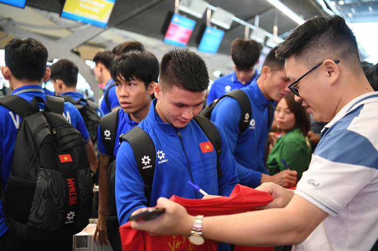 Cổ động viên tranh thủ xin chữ ký các tuyển thủ lên áo đấu.