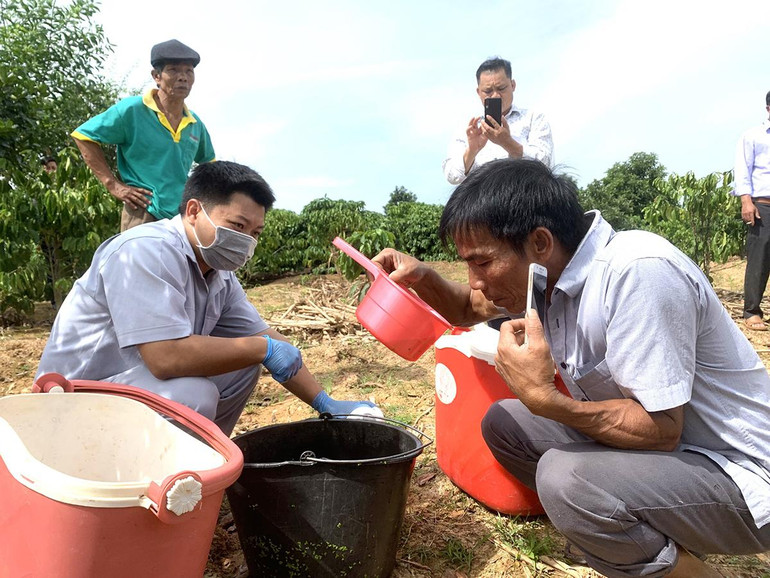 Người dân địa phương kiểm tra nước thải được Đoàn kiểm tra lấy mẫu.