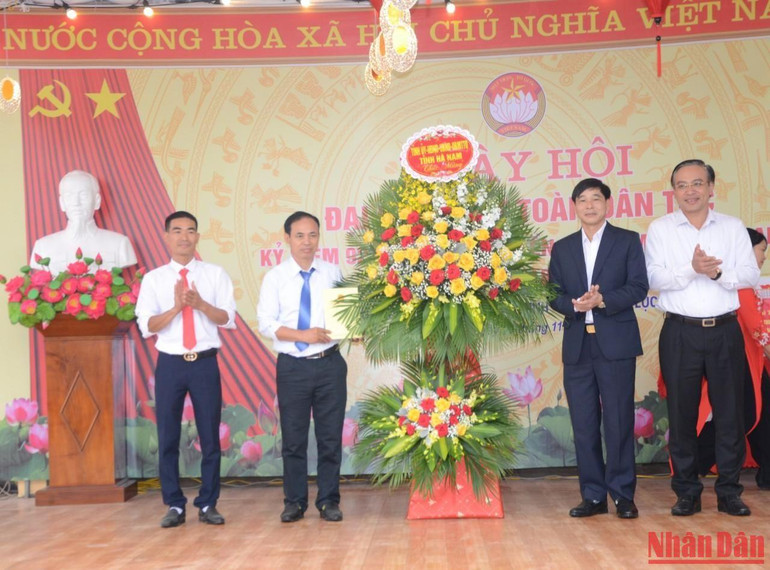 Các đồng chí lãnh đạo tỉnh tặng hoa và quà cho đại diện thôn An Thuận nhân Ngày hội Đại đoàn kết toàn dân tộc.