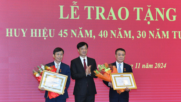 Đồng chí Nguyễn Duy Ngọc, Bí thư Trung ương Đảng, Chánh Văn phòng Trung ương Đảng trao Huy hiệu 40 năm tuổi đảng và tặng hoa chúc mừng các đồng chí cán bộ Văn phòng Trung ương Đảng. (Ảnh: ĐĂNG KHOA)