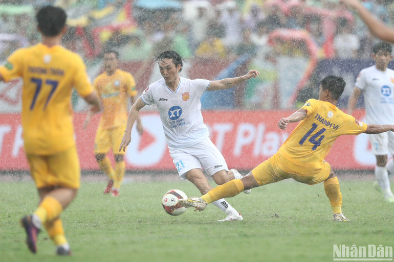 Cơn mưa lớn khiến hai đội thi đấu tương đối khó khăn. (Ảnh: SƠN TÙNG)