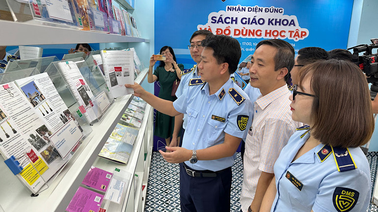 Lãnh đạo Cục Quản lý và Phát triển thị trường trong nước Nguyễn Thanh Bình hướng dẫn người dân phân biệt sách giáo khoa thật giả.