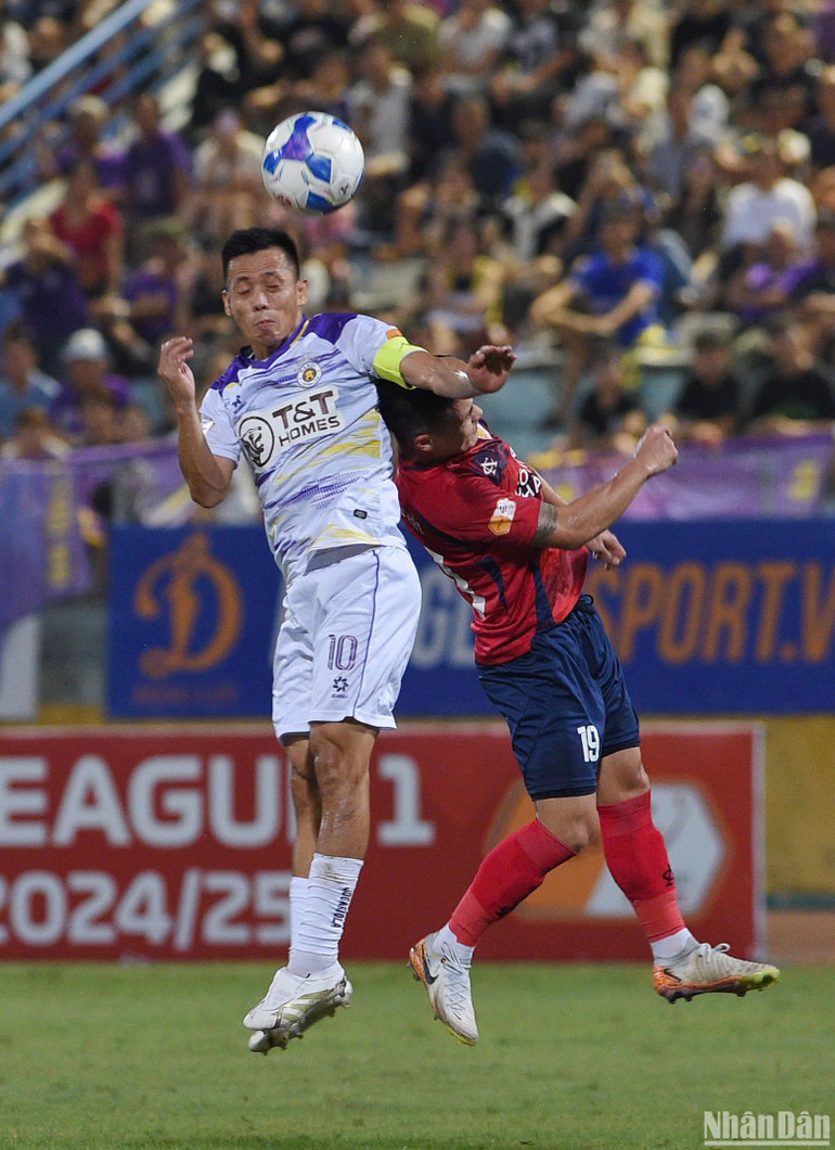 Văn Quyết tranh bóng bổng cùng Quang Hải.