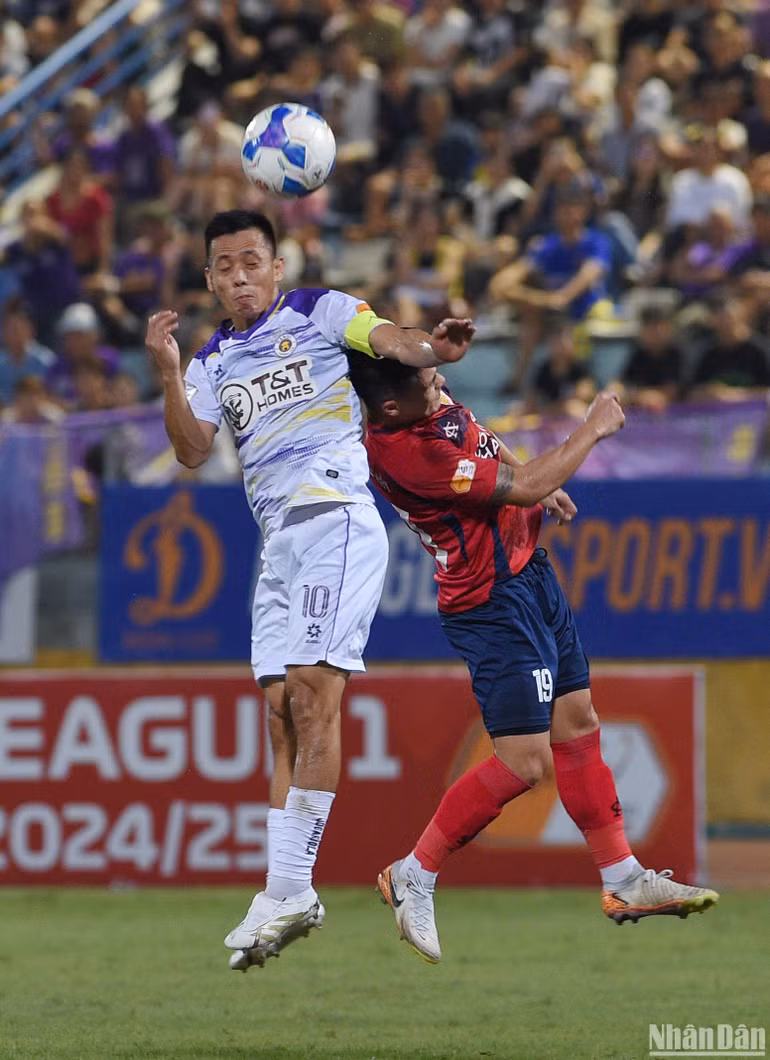 Văn Quyết tranh bóng bổng cùng Quang Hải.
