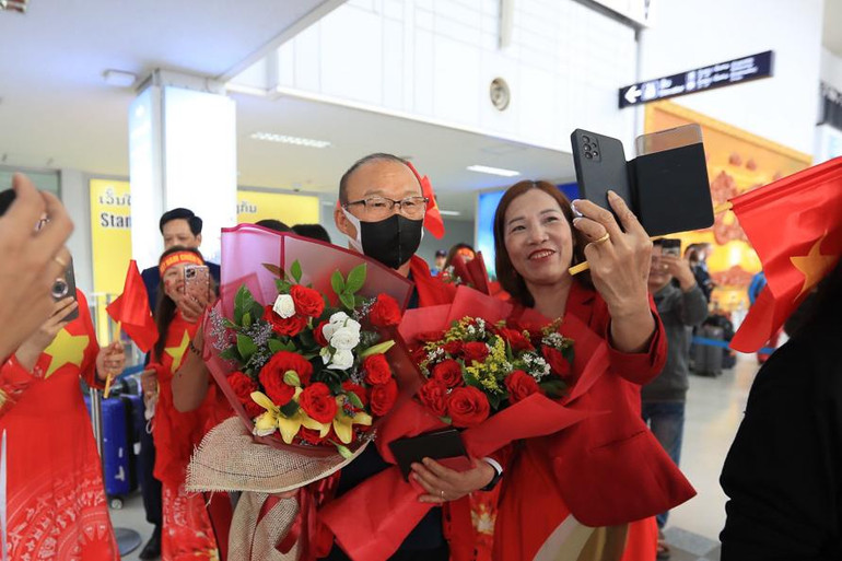 Cổ động viên Việt Nam tại Lào đón đội tại sân bay Wattay và tặng hoa chúc mừng HLV Park Hang-seo. (Ảnh: VFF)