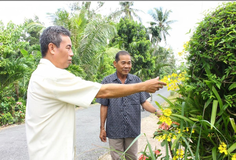 Ông Lê Thanh Dũng (bên trái), cán bộ tuyên giáo-dân vận thị trấn Vĩnh Viễn, huyện Long Mỹ, vận động người dân xây dựng cảnh quan sạch đẹp.