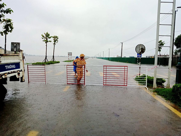 Lực lượng chức năng ngăn đường vùng ngập lụt cấm người dân qua lại.