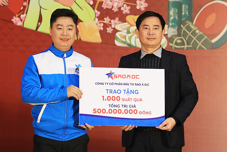 Bí thư Tỉnh đoàn Nghệ An Lê Văn Lương (trái) nhận biển tượng trưng 1.000 suất quà tặng người dân hoàn cảnh khó khăn từ đại diện Công ty Cổ phần đầu tư Sao Á D.C tại chương trình.