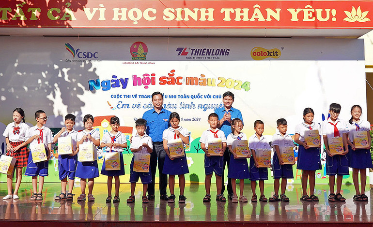 Ban tổ chức trao quà tặng thiếu nhi địa phương có thành tích tốt trong học tập.