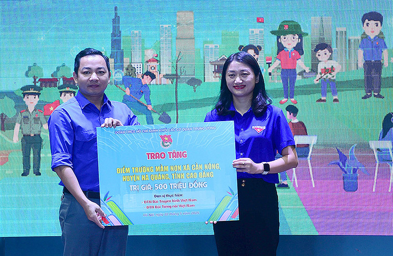 Đại diện Đoàn Thanh niên Đài Truyền hình Việt Nam (bên trái) trao tượng trưng công trình xây dựng điểm trường tại buổi lễ.