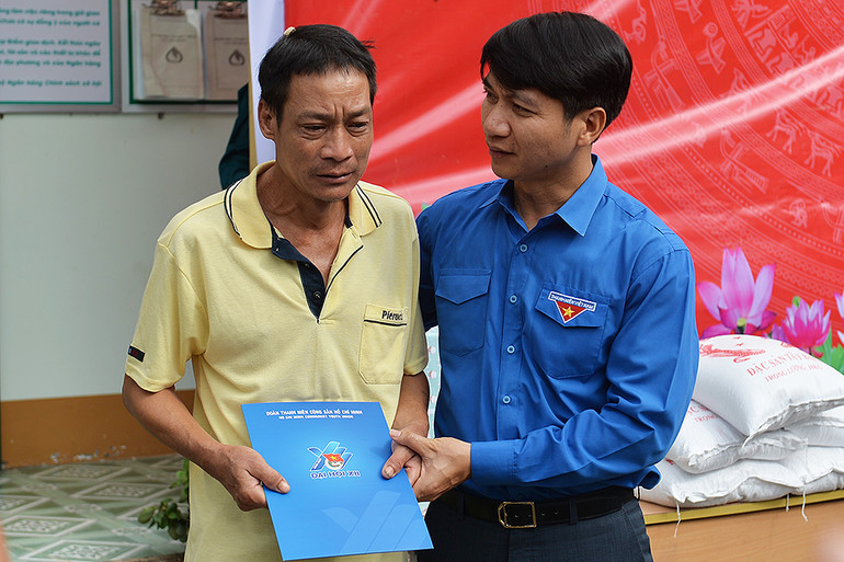 Đồng chí Nguyễn Ngọc Lương trao quà, động viên ông Cà Văn Luyến tại trụ sở Ủy ban nhân dân xã Mường Pồn.