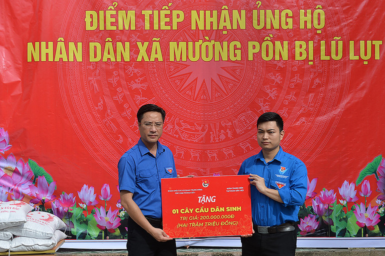 Bí thư Tỉnh đoàn Điện Biên Đặng Thành Huy (trái) trao tượng trưng kinh phí xây dựng "Cầu dân sinh" tặng người dân, thanh thiếu nhi Mường Pồn.
