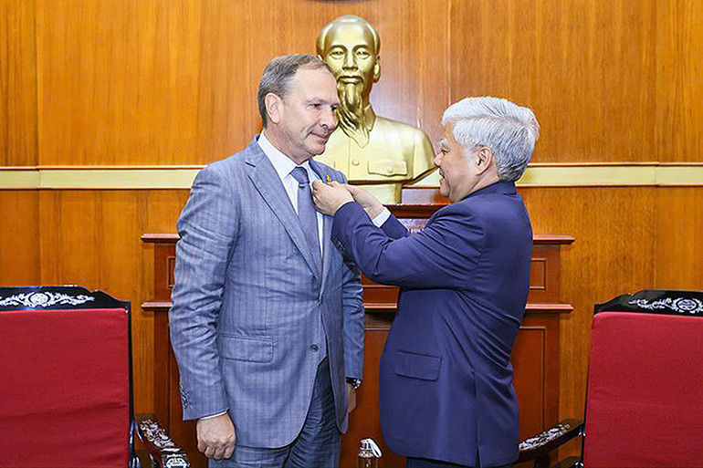 Đồng chí Đỗ Văn Chiến trao Huy hiệu biểu trưng của Mặt trận Tổ quốc Việt Nam tặng ông Alexander Shkolnik.