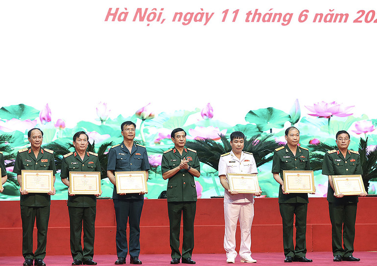 Đại tướng Phan Văn Giang (đứng giữa) trao Bằng khen tặng các tác giả, đại diện nhóm tác giả giành giải Nhất tại buổi lễ.