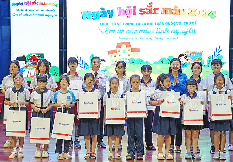 Bí thư Trung ương Đoàn, Chủ tịch Hội đồng Đội Trung ương Nguyễn Phạm Duy Trang (áo xanh) và đại diện các đơn vị liên quan trao quà tặng thiếu nhi có thành tích tốt trong học tập.