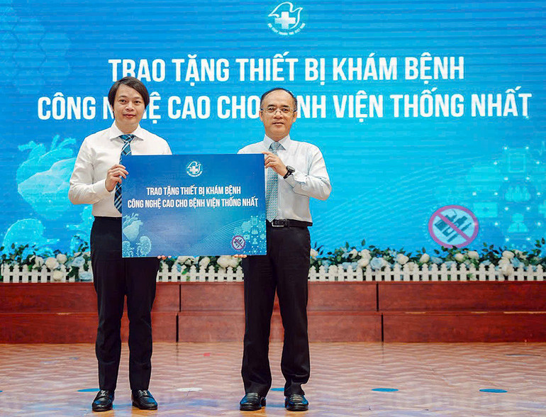 Đồng chí Nguyễn Hữu Tú (bên trái) trao tượng trưng các thiết bị y tế tặng Bệnh viện Thống Nhất.