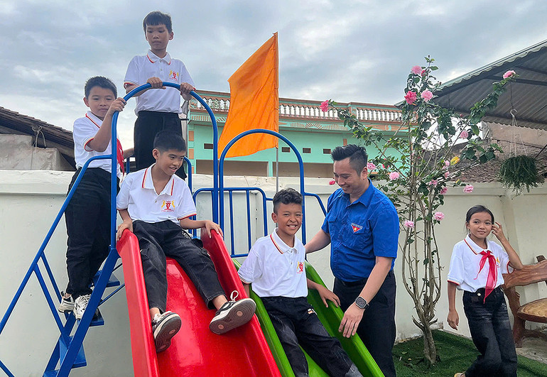 Phó Chủ tịch Hội đồng Đội Trung ương, Giám đốc Trung tâm Hỗ trợ và Phát triển Thiếu nhi Việt Nam Lê Anh Quân và học sinh Trường tiểu học Đông Quan bên công trình "Sân chơi thiếu nhi".