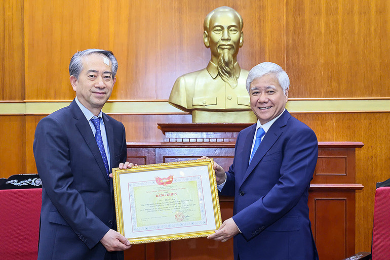 Đồng chí Đỗ Văn Chiến (bên phải) trao Bằng khen tặng Đại sứ Hùng Ba.