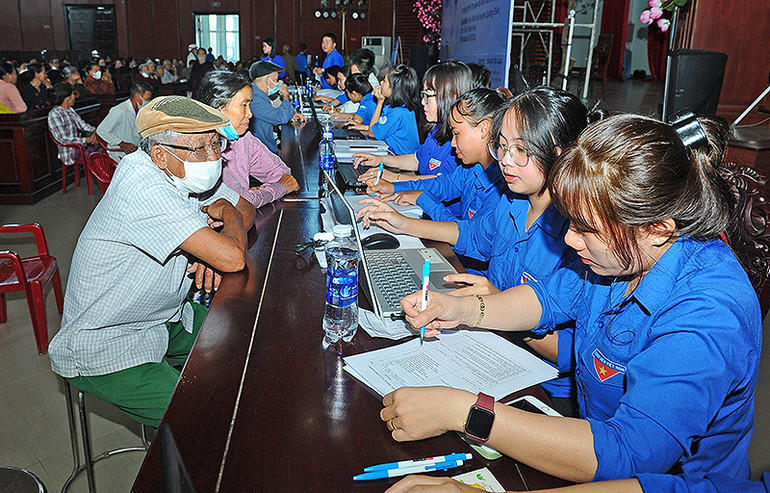 Đoàn viên, thanh niên tình nguyện hỗ trợ người cao tuổi đăng ký khám, tầm soát bệnh sau buổi lễ.