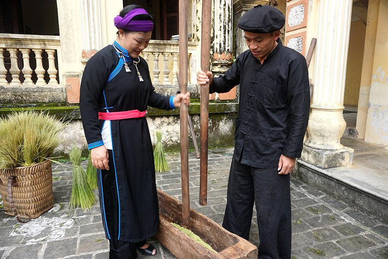 Hạt lúa được rang chín và cho vào cối gỗ để giã cho bong vỏ trấu. (Ảnh: MINH TÂM) Hạt lúa được rang chín và cho vào cối gỗ để giã cho bong vỏ trấu. (Ảnh: MINH TÂM)