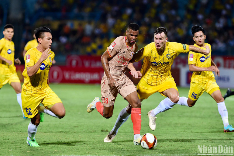 Ngoại binh Công an Hà Nội trong vòng vây các cầu thủ áo vàng.