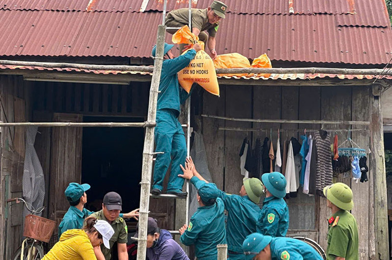 Lực lượng vũ trang giúp người dân huyện Tiên Phước chằng chống lại nhà cửa, ứng phó bão số 6.