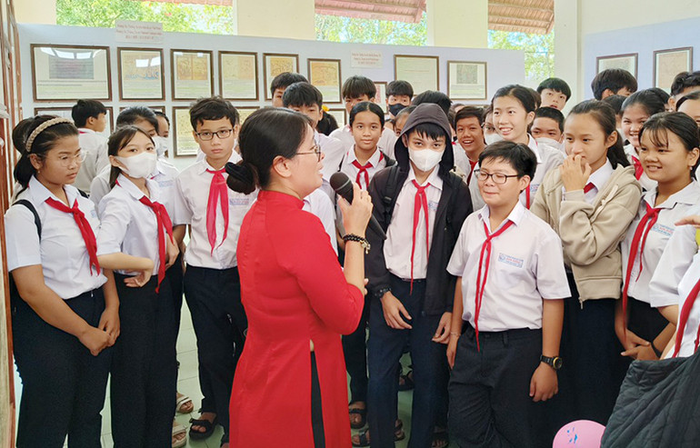 Các em học sinh của huyện Núi Thành (Quảng Nam) nghe giới thiệu những tư liệu, bản đồ về hai quần đảo Hoàng Sa và Trường Sa của Việt Nam.